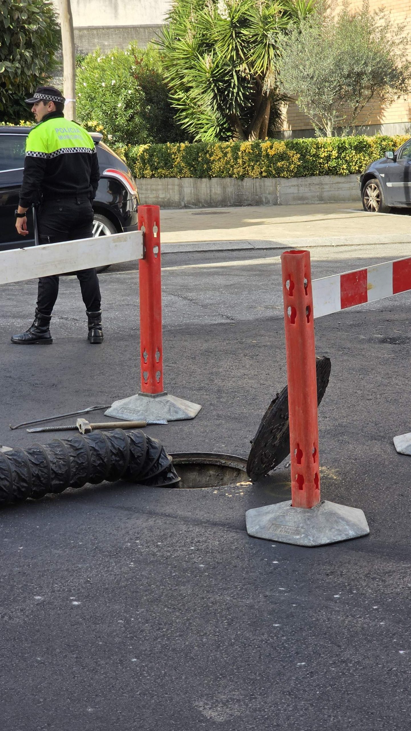 Extrator de gases instalado numa boca de visita em Ermesinde, com mangueira, grades de proteção e agente da Polícia Municipal